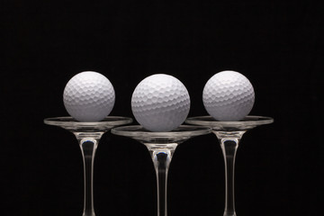 Three glasses of champagne and golf balls