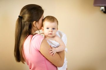 Young woman holding a baby in a towel