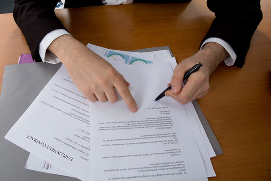 Close-up of female hand pointing at business document 
