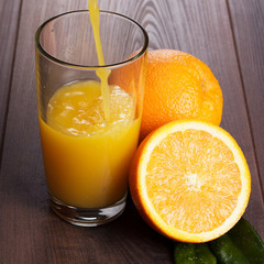 fresh orange juice pouring into glass on the table