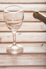 Wine glass with bottle on wooden background dreamy look