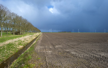 Plowed field under a rain shower in spring