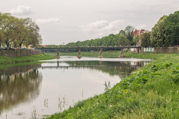 river flow in town and green grass on banks