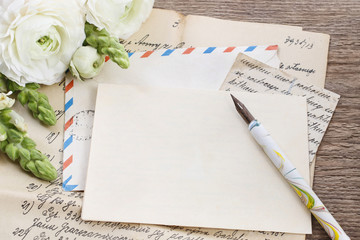 Vintage letters, ink and pen. White persian buttercup flowers