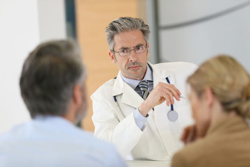 Obraz premium Doctor meeting couple in hospital office