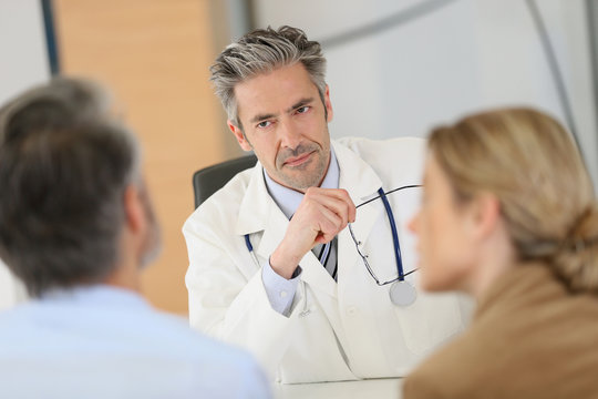 Doctor meeting couple in hospital office