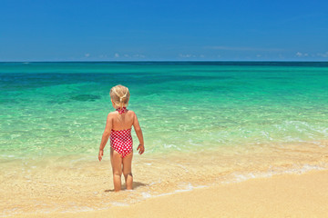 Fototapeta premium Girl standing on the sand beacn