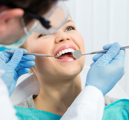 Dental health. Male hygienist examining patient teeth on caries