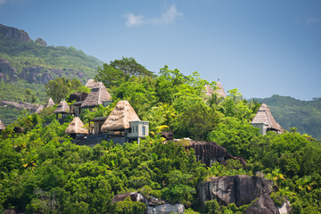 Fototapeta na wymiar View of Seychelles coastline with houses in the forest