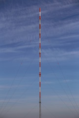 Obraz premium Symmetric view of red and white radio tower