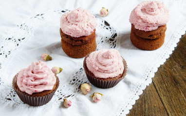 Cupcakes with cream cheese cream with raspberry and dry roses