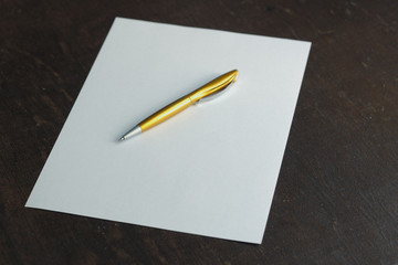 sheet of paper and golden pen