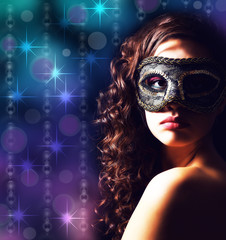 Beautiful girl with masquerade mask on lights background