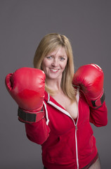 Blond female boxer with red gloves and jacket