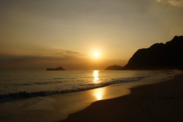 Naklejka premium Early Morning Sunrise on Waimanalo Beach over Rock Island bursti