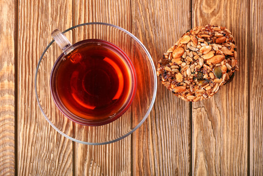 Cup of brown tea healthy cereals seed cookies on wooden table