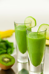 Green Smoothie with Fruits in Background
