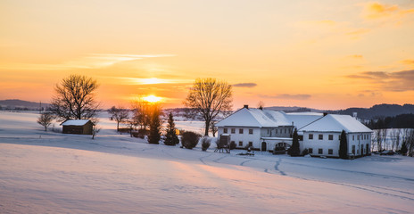 Farmhouse in a winter landscape at sunrise