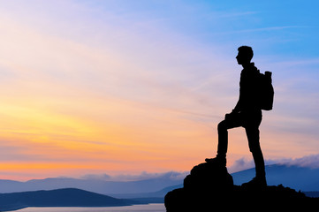 Silhouette of man at the top of the mountain on sunset - 80874095