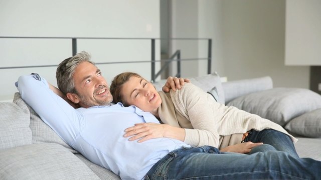 Mature couple relaxing together in couch 