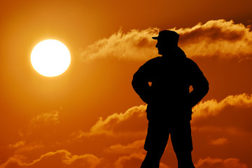 Silhouette of military soldier officer with weapons at sunset