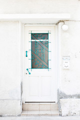 Old white front door in mediterranean city.