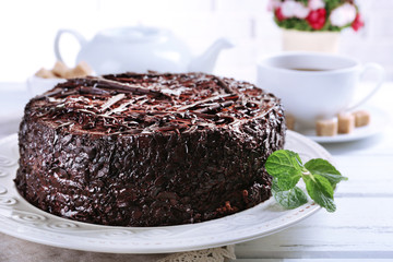 Tasty chocolate cake with mint on table close up