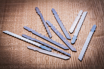 composition of blades for electric jigsaw on vintage wooden boar