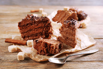 Fototapeta na wymiar Slices of tasty chocolate cake on plate on table close up