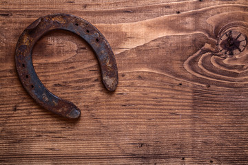 single vintage rusted horseshoe on old wooden board with copyspa