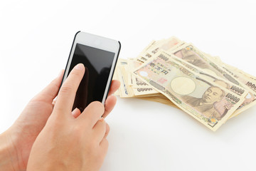 日本の紙幣とスマートフォン