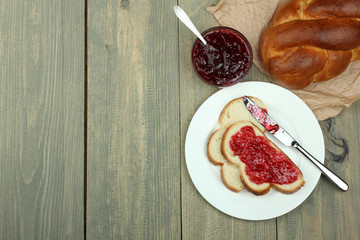 Toast with strawberry jam on a plate on a wooden background