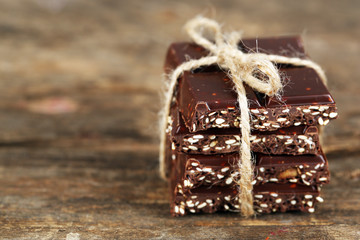 Stack of tied chocolate on wooden background