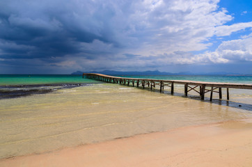 Fototapeta na wymiar Wooden pier on Alcudia beach, Majorca island, Spain