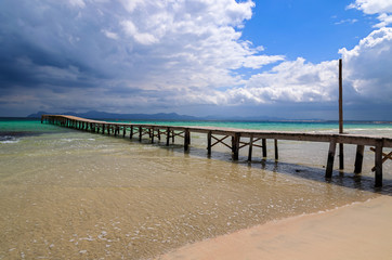 Fototapeta na wymiar Wooden pier on Alcudia beach, Majorca island, Spain
