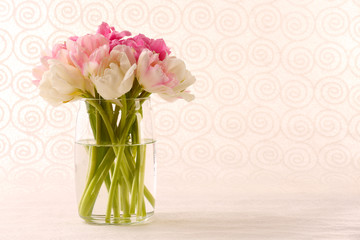 Bouquet of fresh tulips on pattern wallpaper background