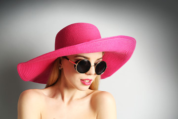 Portrait of expressive young model in pink hat and sunglasses , closeup