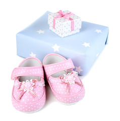 Baby shoes with gifts isolated on white
