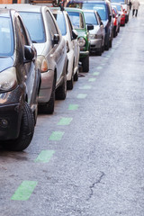 Obraz premium Reihe geparkter Autos am Straßenrand