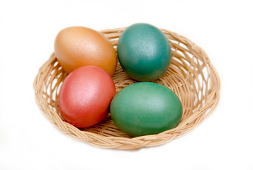 Basket with colored eggs on white background