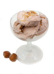 Cup of ice cream with hazelnut on white background top view