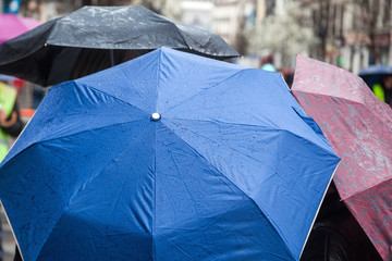 Menschen mit Regenschirmen in der Stadt unterwegs
