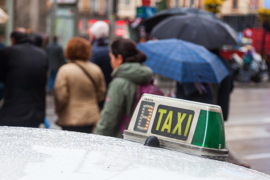 Taxischild mit Menschen im unscharfen Hintergrund