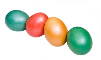 Oblique row of colored eggs on white background