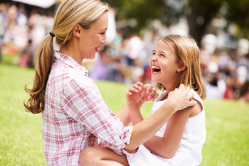 Mother And Daughter Relaxing At Outdoor Summer Event