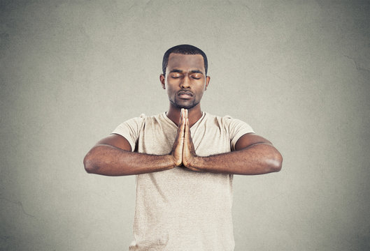 Handsome man doing yoga isolated on gray wall background 