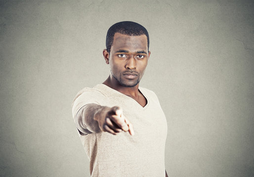 Closeup portrait man pointing finger isolated grey background.
