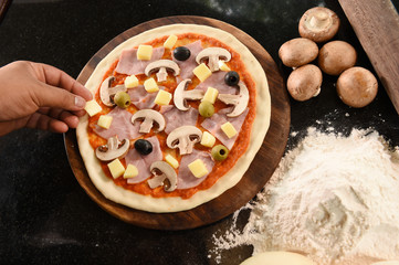 pizza and ingredients for pizza on the wooden background