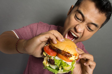 Young Man have a great desire to eat a burger