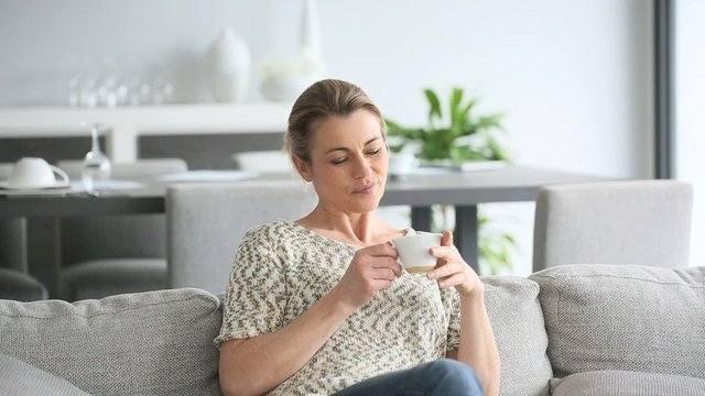 Woman relaxing in sofa, husband and son coming to her
